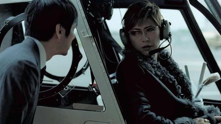 　横の座席にトイレブラシを置きヘリコプターに乗り込むＧＡＣＫＴと、置いて行かれる西島秀俊（左）