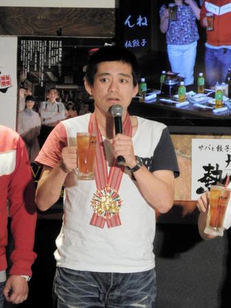 博多町人文化勲章で、もらったメダルをかけて乾杯のあいさつをする博多華丸＝東京・上野