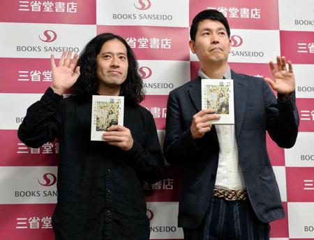 本を持ち、手を振る又吉直樹（左）と堀本裕樹氏＝東京交通会館（撮影・西岡正）