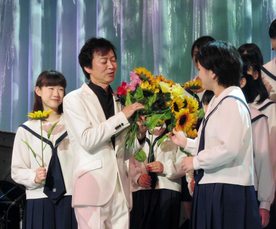 　杉並児童合唱団のメンバーから花を贈られる新沼謙治＝東京・蒲田