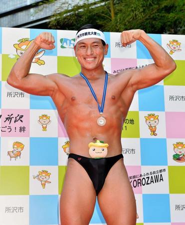 所沢市のマスコット『トコろん』のぬいぐるみをパンツに挟みポーズを決める春日俊彰＝埼玉・所沢市役所（撮影・園田高夫）