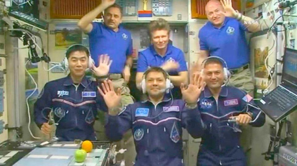 　国際宇宙ステーションに到着し、地上の家族と交信するイベントで手を振る油井亀美也さん（左端）（ＮＡＳＡテレビから）