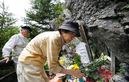 「御巣鷹の尾根」の墓標に花を供える、娘３人を亡くした田淵親吾さん（左）と妻の輝子さん＝群馬県上野村