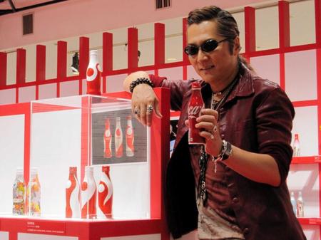 　コカ・コーラボトルを手に、自らデザインしたボトルを披露する石井竜也＝東京・伊勢丹新宿店