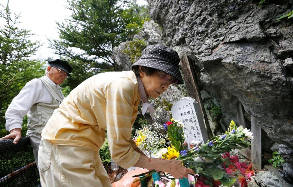 「御巣鷹の尾根」の墓標に花を供える、娘３人を亡くした田淵親吾さん（左）と妻の輝子さん＝群馬県上野村