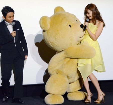 　映画「テッド２」のＰＲイベントで、テッドに抱きつかれる小嶋陽菜。左は有吉弘行＝18日、東京都内