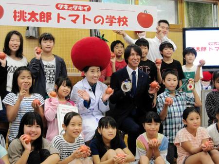 　児童たちと笑顔を見せるキンタロー。（中列左から３人目）と葛西紀明（同４人目）＝東京都品川区の上神明小学校