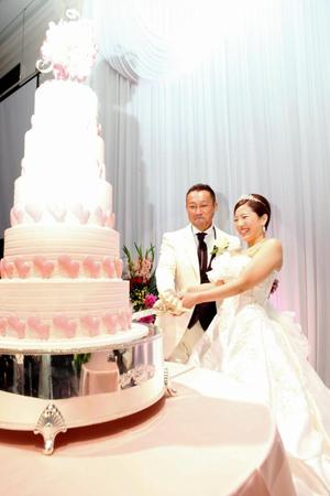 ウエディングケーキに入刀する薬師寺保栄（左）とまきこさん＝名古屋市内のホテル