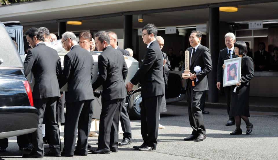 関係者の手により運ばれる川島なお美さんの棺と感極まる鎧塚俊彦氏＝青山葬儀所（撮影・田村亮介）