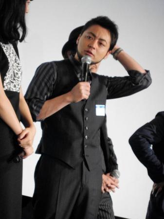 スタッフ用のシールを左胸に貼ったまま舞台あいさつ登場した山田孝之＝東京・有楽町