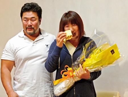 報道陣から退院祝いの花束をもらい涙をみせる北斗晶（右）と寄り添う夫の佐々木健介＝吉川市の健介オフィス（撮影・三好信也）