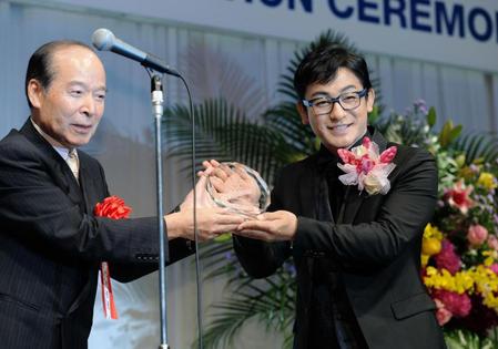 メガネドレッサー賞授賞式でソロフィーを受け取る片岡愛之助（右）＝東京ビッグサイト（撮影・開出牧）