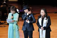 自らのメッセージを代読するクミコ（左）の横で赤ちゃんを抱っこするポーズを見せるつんく♂（中央）（右は湯川れい子）＝東京・学習院大学百周年記念会館（撮影・園田高夫）