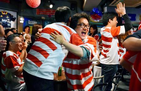 　日本のトライが決まり、抱き合って喜ぶファン＝東京・高田馬場　