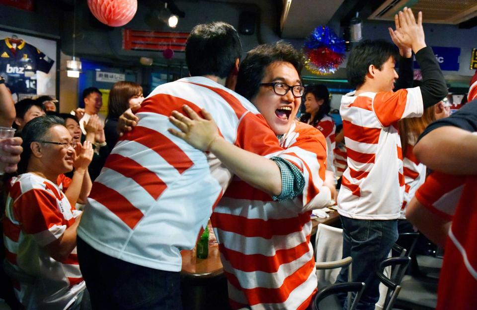 　日本のトライが決まり、抱き合って喜ぶファン＝東京・高田馬場　
