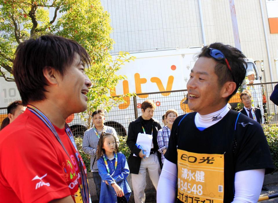 「大阪マラソン」を完走し、コブクロ・小渕健太郎（左）からねぎらわれる清水健アナウンサー＝大阪市内