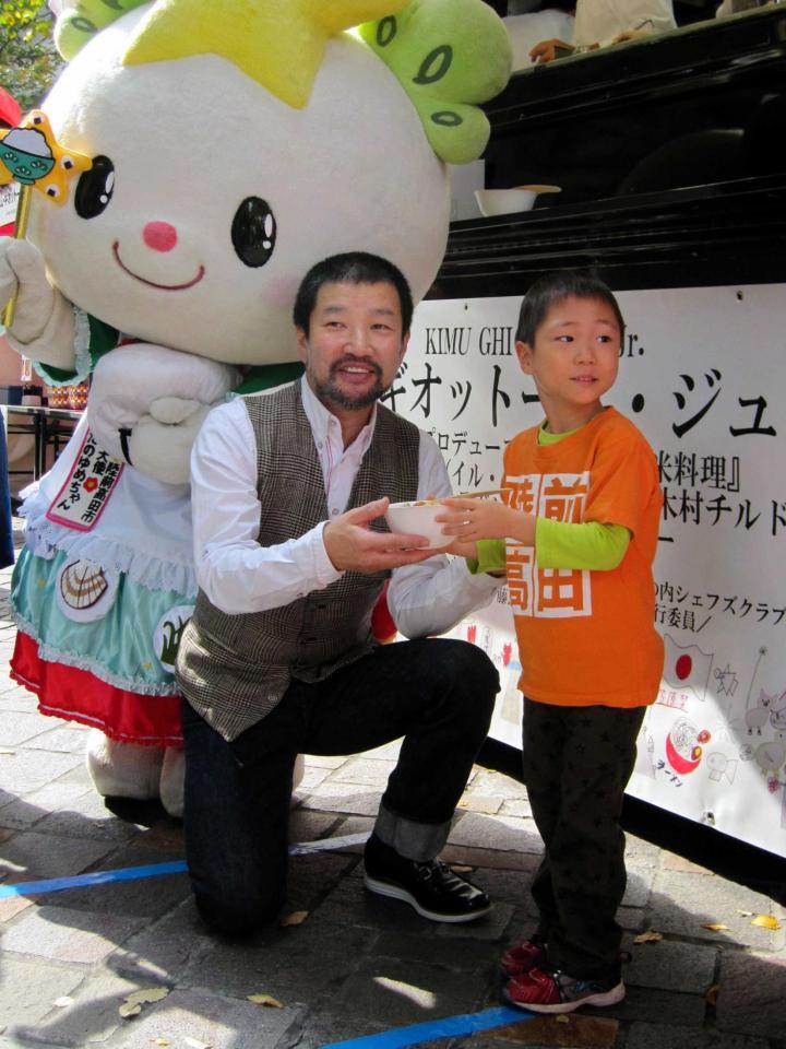 男の子に料理を渡す木村祐一＝東京・丸の内