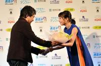是枝裕和監督（左）から祝福の花束を渡される広瀬すず＝ザ・プリンスパークタワー東京（撮影・園田高夫）