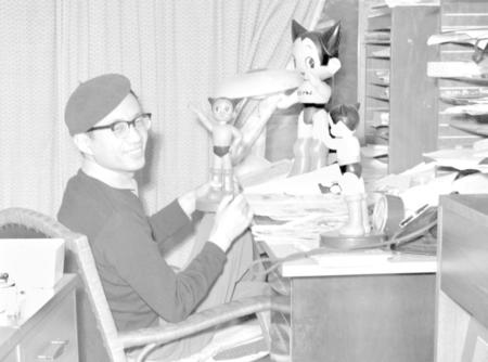 仕事場で鉄腕アトムの人形を手にする手塚治虫さん＝１９６３年５月