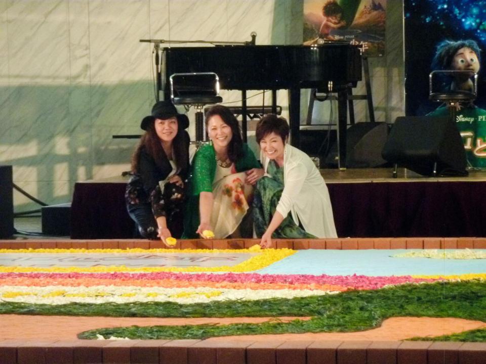 フラワーカーペットを完成させるＫｉｒｏｒｏの金城綾乃（右）、玉城千春（中央）と友人の振り付け師・新垣寿子さん＝晴海トリトンスクエア