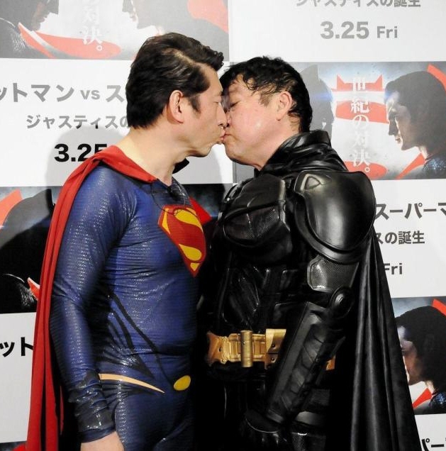 スーパーマンにふんした寺門ジモン（左）とチューをするバットマンにふんした上島竜兵＝東京・ワーナーブラザーズ試写室