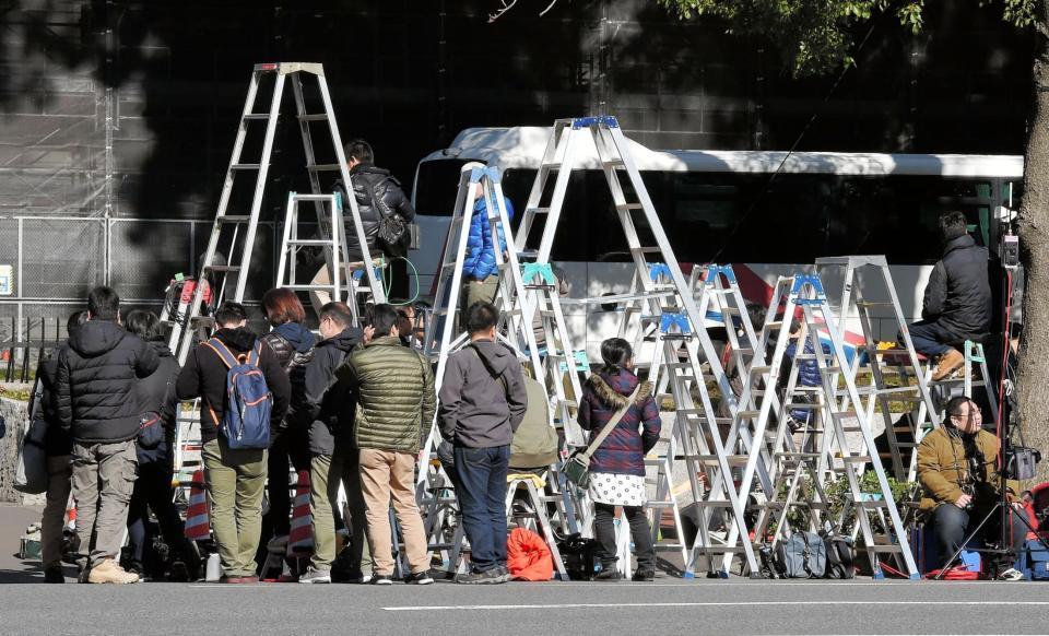清原被告の保釈に備え、警視庁前で待機する大勢の報道陣と並べられた脚立＝東京・桜田門
