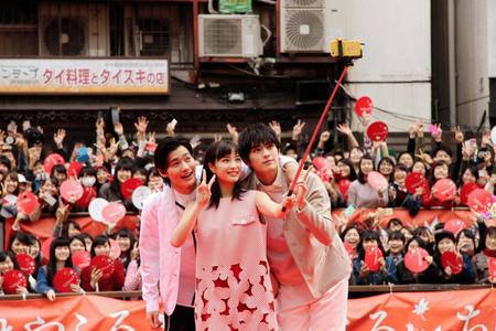 集まった観衆とともに写真を撮る（左から）野村周平、広瀬すず、真剣佑＝大阪市内