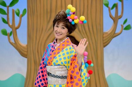 子供向けのカラフルな衣装で「歌のお姉さん」を務める小林幸子