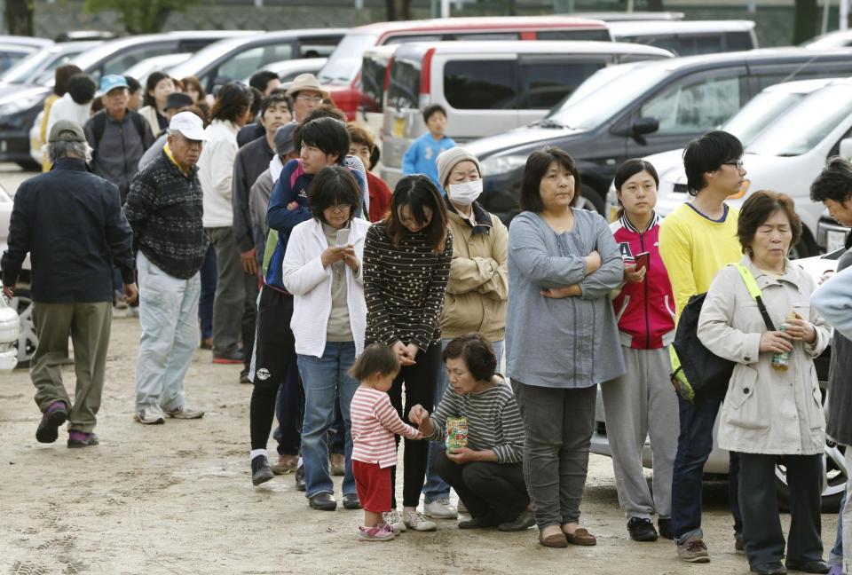 　避難所となった小学校で、食料などの配給に並ぶ人たち＝17日午前７時８分、熊本県益城町