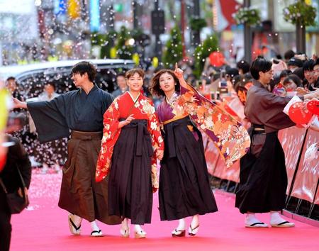 仲良く手をつないでレッドカーペットを歩く広瀬すず（中央左）と松岡茉優（同右）＝東京・新宿歌舞伎町セントラルロード