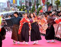 仲良く手をつないでレッドカーペットを歩く広瀬すず（中央左）と松岡茉優（同右）＝東京・新宿歌舞伎町セントラルロード