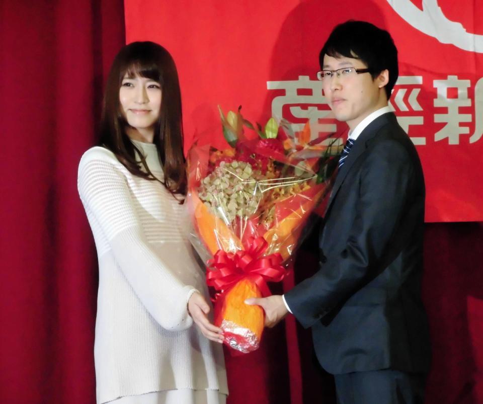 囲碁界史上初の七冠独占を達成し、タレントの戸島花（左）から花束を受け取る井山裕太＝東京・日本棋院