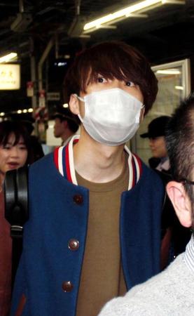 　関係者にガードされながら新幹線のホームを歩く川谷絵音＝新大阪駅