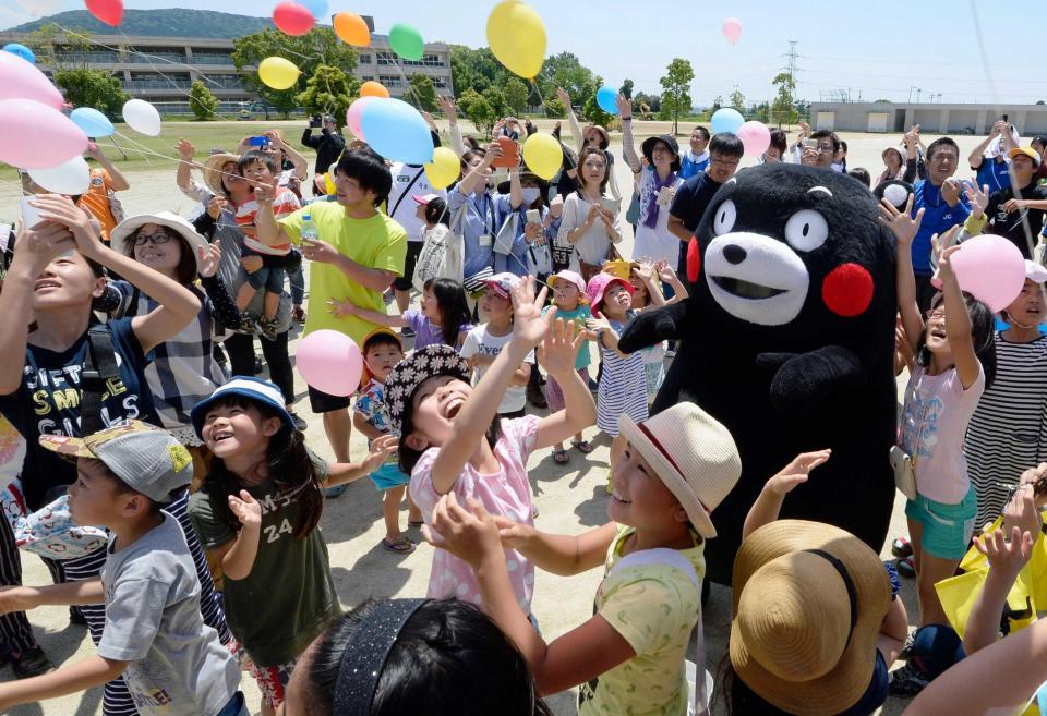 　避難所になっている小学校で、子どもたちと風船を飛ばすくまモン