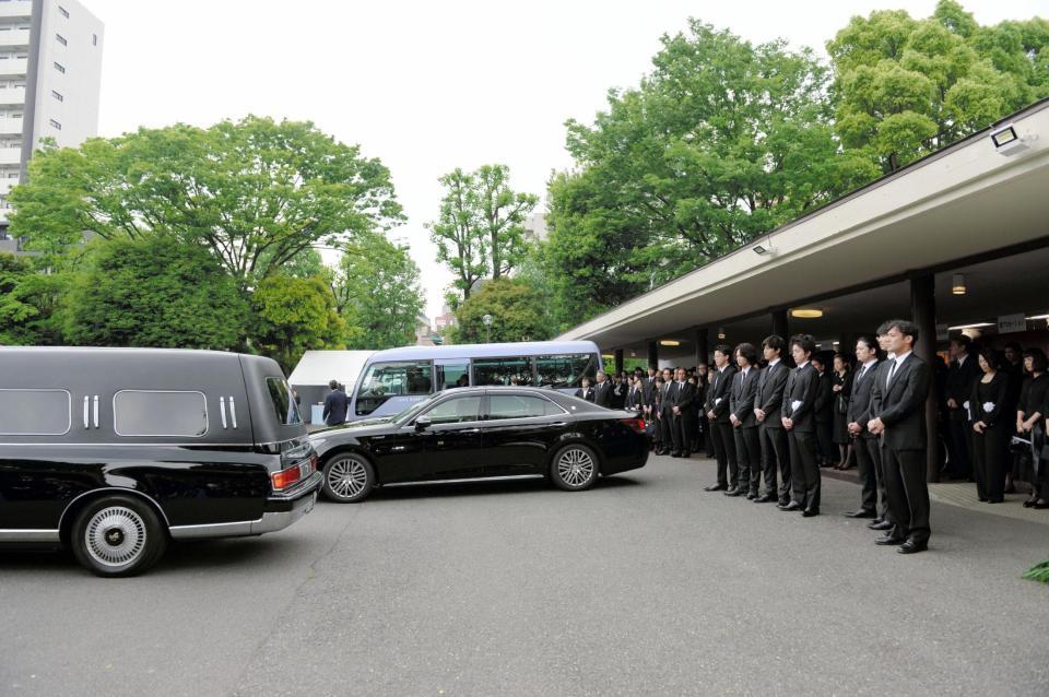 蜷川幸雄さんの棺を乗せた霊柩車（左）を見送る弔問客（右）＝青山葬儀所（撮影・開出牧）