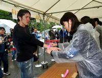 午前３時３０分から並んだ男性が１番のリストバンドを腕に巻かれる＝東京都千代田区の日比谷公園（撮影・出月俊成）