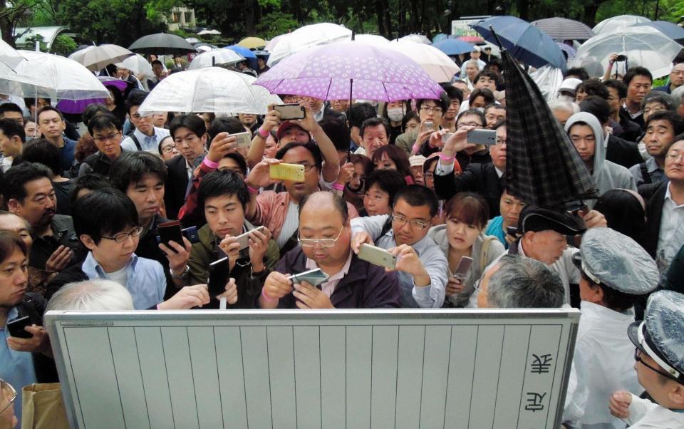 傍聴券の当選番号を確認するため掲示板に集まる人々＝東京・日比谷公園（撮影・村中拓久）