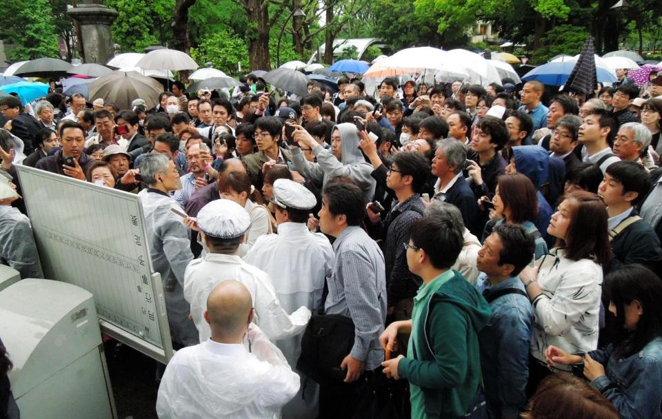 傍聴券の当選番号を確認するため掲示板に集まる人々＝東京・日比谷公園（撮影・村中拓久）