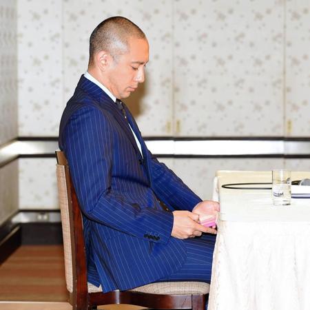 会見中にスマートフォンをチェックする市川海老蔵＝都内のホテル（撮影・棚橋慶太）