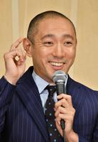 目尻に指を持って行く市川海老蔵。連射されるシャッター音に苦笑い＝都内のホテル