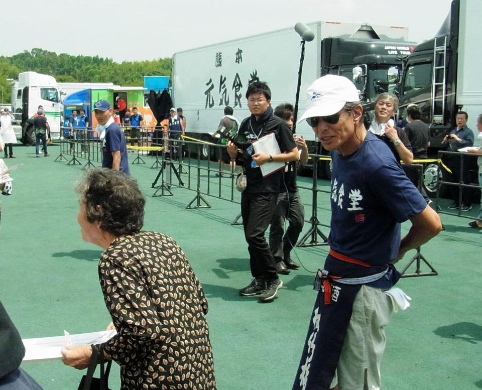 被災者たちを出迎える舘ひろし＝熊本県益城町