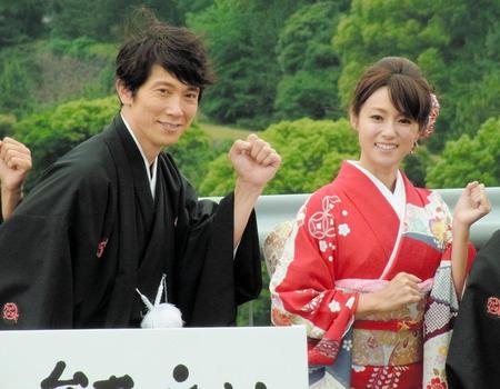 皇居をバックに走るポーズをする佐々木蔵之介（左）と深田恭子＝東京・竹橋