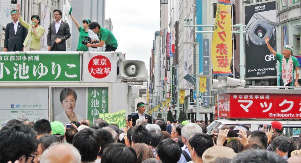 　緑色ファッションのマック赤坂氏（右）からエールを送られた小池百合子氏＝東京・銀座