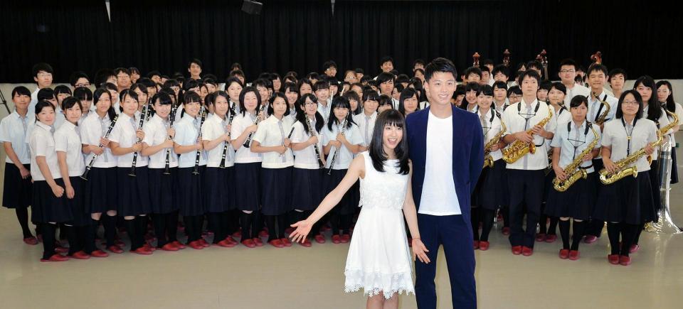 市立尼崎高校の吹奏楽部と記念撮影する土屋太鳳さん（前列左）と竹内涼真さん（同右）＝８日午後、尼崎市内（撮影・三津山朋彦）