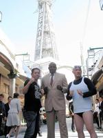 通天閣をバックにポーズを決める（左から）ＦＵＪＩＷＡＲＡ・原西、アーネスト・ホースト、くまだまさし＝大阪市内