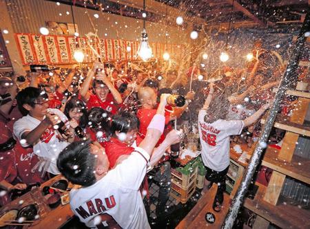 　広島の優勝が決まり、大喜びでビールかけをするカープファン＝広島市内