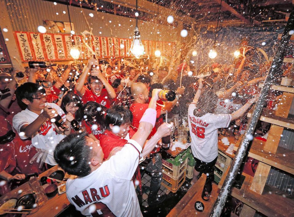 　広島の優勝が決まり、大喜びでビールかけをするカープファン＝広島市内