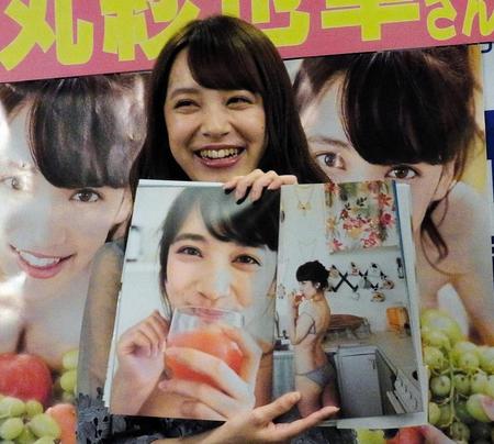 お気に入りのページを広げ、笑顔の都丸紗也華＝東京・新宿のブックファースト