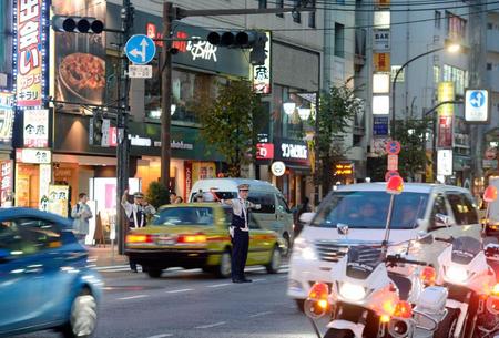 　信号機（左上）が点灯せず、手信号で交通整理する警察官＝東京都豊島区