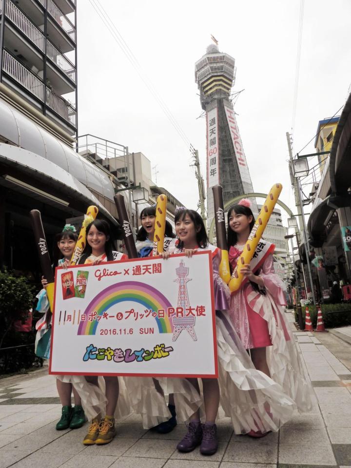 通天閣をバックに「ポッキー＆プリッツの日」をＰＲしたたこやきレインボーの（左から）根岸可蓮、清井咲希、春名真依、堀くるみ、彩木咲良＝大阪市の通天閣
